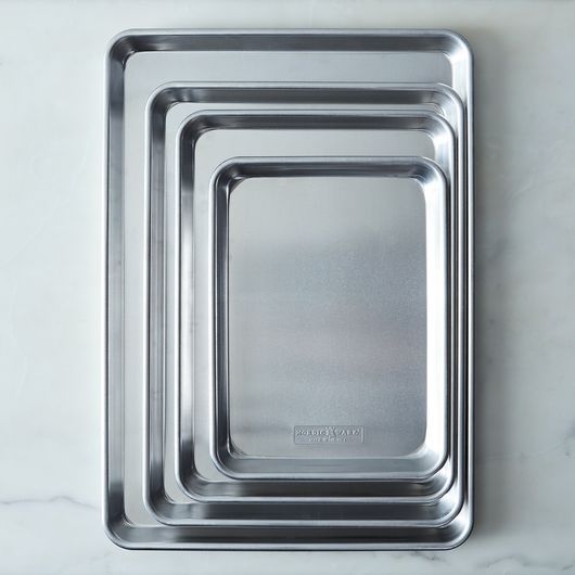 three metal trays sitting on top of a marble counter