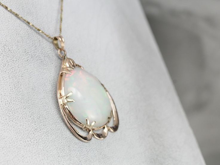 This vintage rose gold pendant is a great frame for the outstanding Opal gemstone that we've set at the center. This is a wonderful stone, filled not only with greens and oranges but also with a rare, pink glow at the center! The perfectly proportioned teardrop shape creates an outstanding profile along the throat. This pendant does not come with the chain shown. Please feel free to contact us, we will help you find the perfect chain for your style and budget! Metal: 10K/18K Rose Gold Gem: Opal Rose Gold Collectible Necklaces, Collectible Rose Gold Necklaces, Antique Oval Cabochon Gemstone Necklaces, Classic Pendant Jewelry With Cabochon, Elegant Opal Jewelry With Large Pendant, Classic Cabochon Pendant Jewelry, Elegant Opal Necklace With Large Pendant, Antique Teardrop Cabochon Jewelry, Antique Opal Jewelry In Yellow Gold