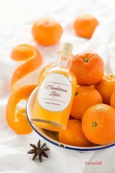 a bowl filled with oranges and anise on top of a white table cloth