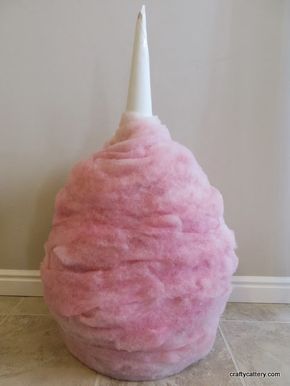 a pink ball with a white candle sticking out of it's center sits on the floor