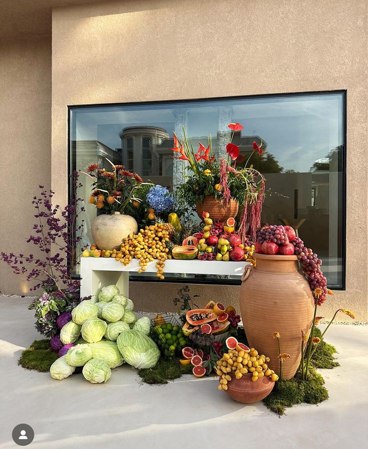 an assortment of fruits and vegetables on display in front of a window