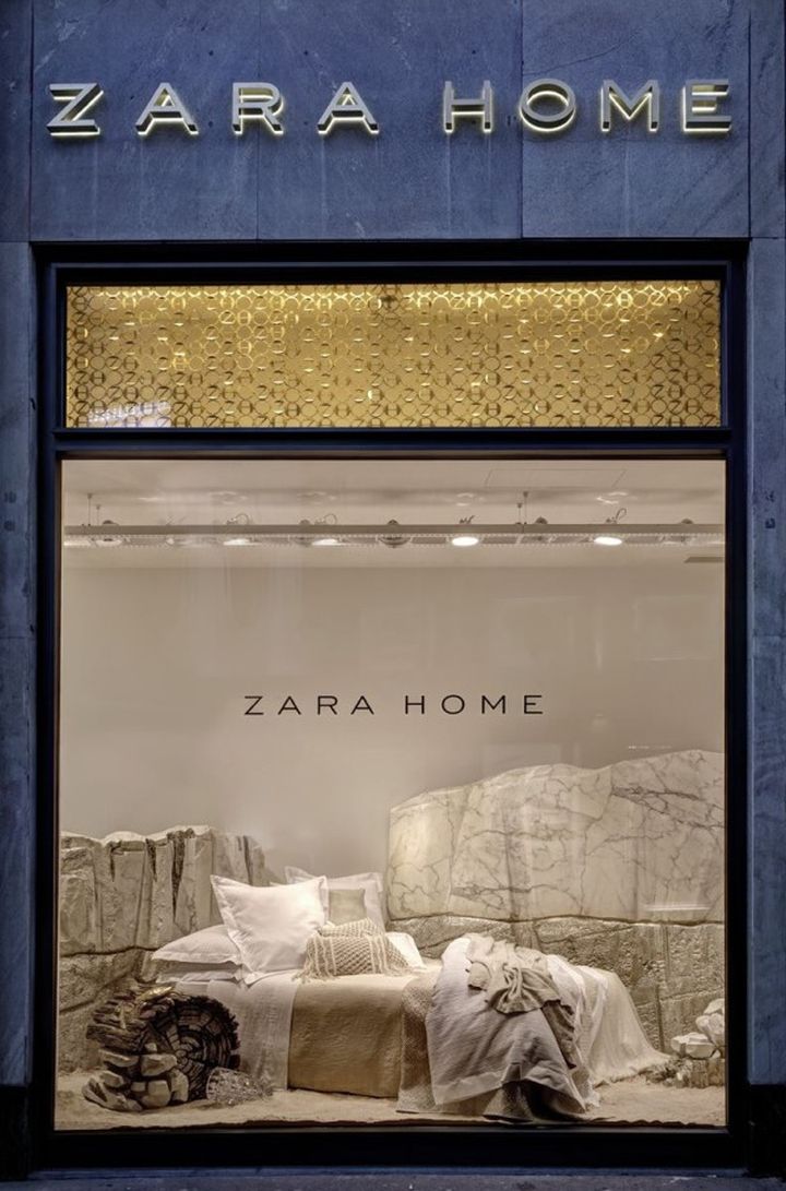 a store window with pillows and blankets in the windows display it's name zara home