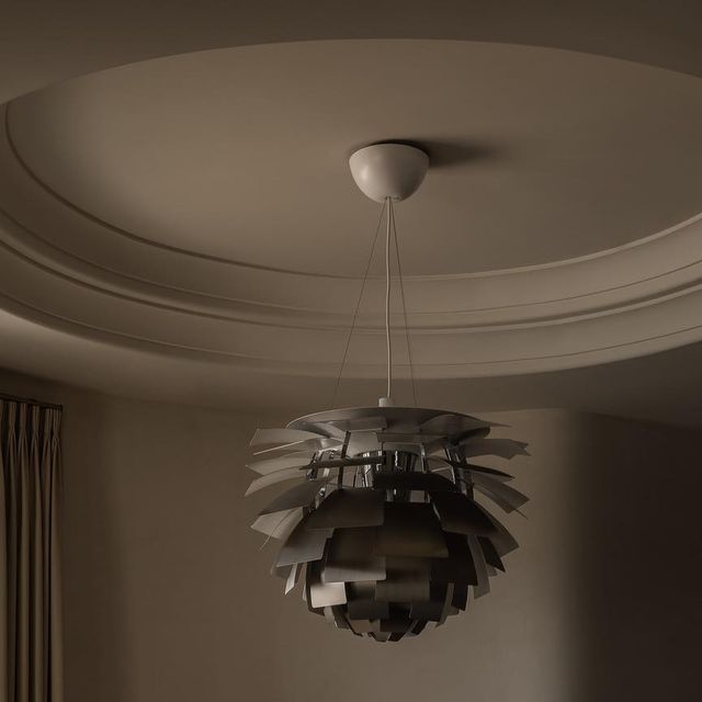 a lamp that is hanging from the ceiling in a room with a round light fixture