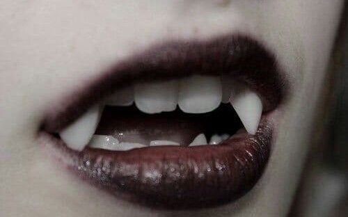 black and white photograph of woman's mouth with long, dark lipstick on it