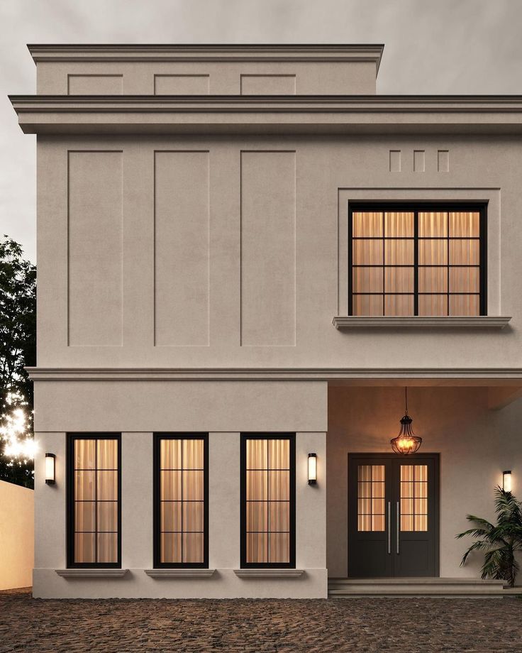 an exterior view of a two story house with three windows and lights on the side