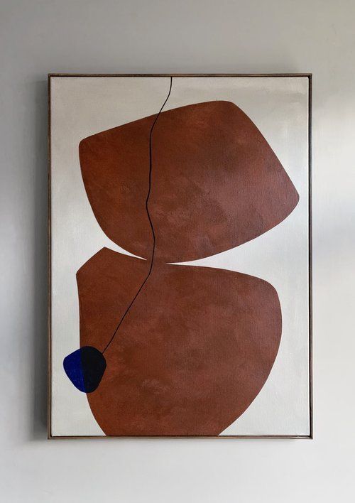 an abstract painting hangs on the wall