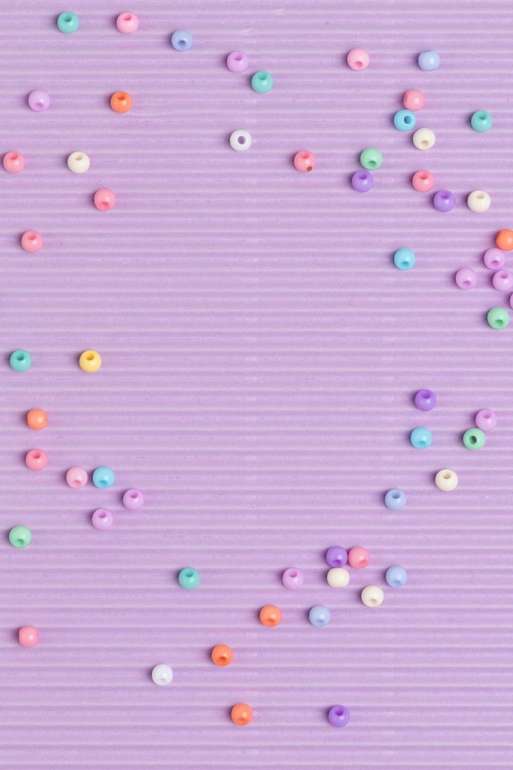 colorful sprinkles are scattered on a purple background with vertical lines in the center