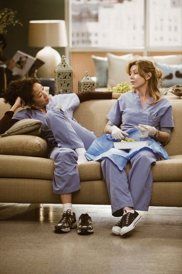 two women in scrubs sitting on a couch