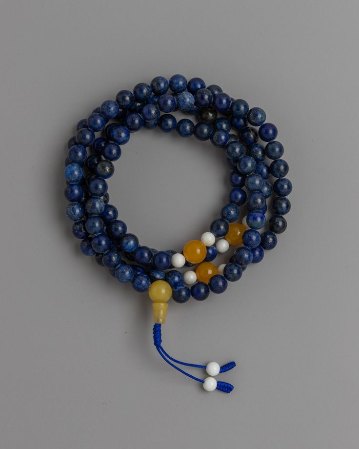 3A Quality Lapis Mala About our Mala Beads Originating in India, the 3A Quality Lapis Mala is a testament to both spiritual significance and expert craftsmanship. The 6mm lapis lazuli beads used in each carefully made mala are prized for their deep blue hue and special qualities. Enhanced with conch and yellow jade dividers, the mala is a symbol of spiritual awakening and prosperity in addition to elegance.The 3A Quality Lapis Mala is a tactile and visual journey towards inner serenity and self- Blue Hand Knotted Round Bead Necklaces, Blue Hand-knotted Round Bead Necklaces, Blue Hand-knotted Necklaces, Blue Round Beads Mala For Meditation, Spiritual Polished Lapis Lazuli Beads, Adjustable Lapis Lazuli Beaded Necklace With 8mm Beads, Blue Spiritual Necklaces For Rituals, Spiritual Blue Necklaces For Rituals, Blue Spiritual Mala With 8mm Beads