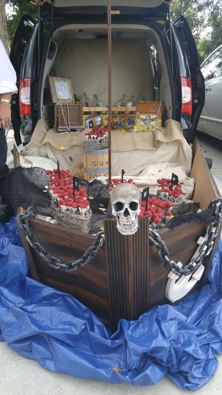 the trunk of a van is decorated with pirate decorations and skulls, including a skull head