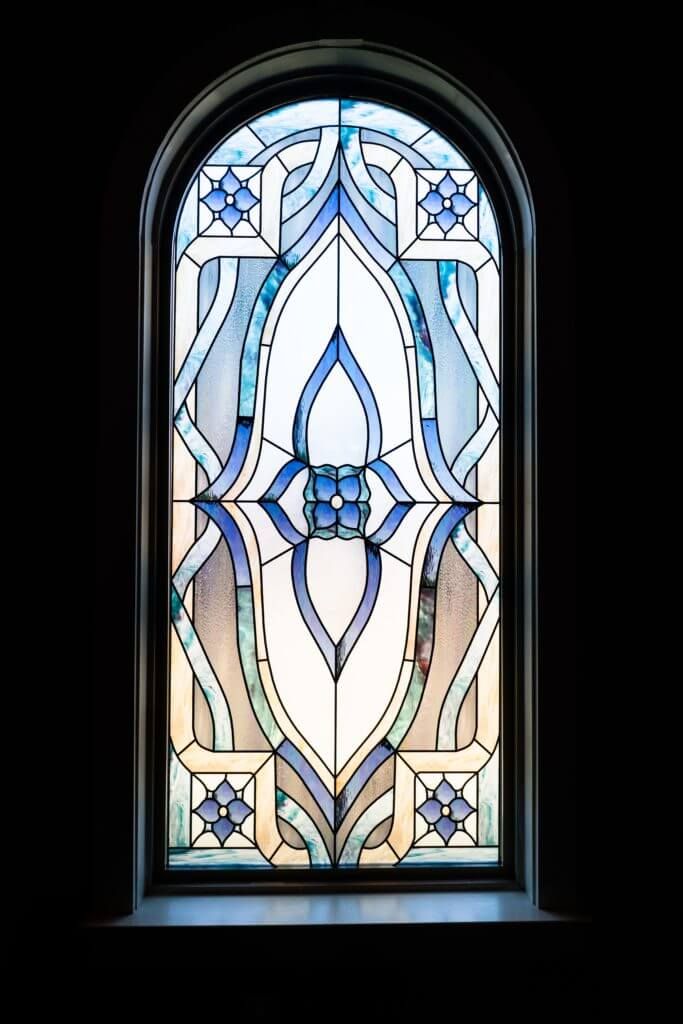 an ornate stained glass window in a dark room