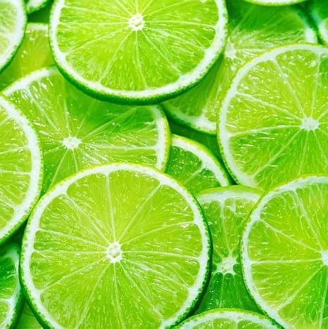 many limes are arranged in rows on top of each other, with one cut in half