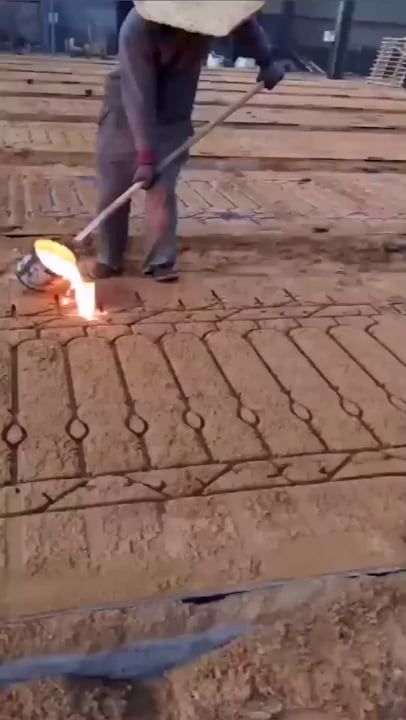 a man is using a stick to put bricks on the ground