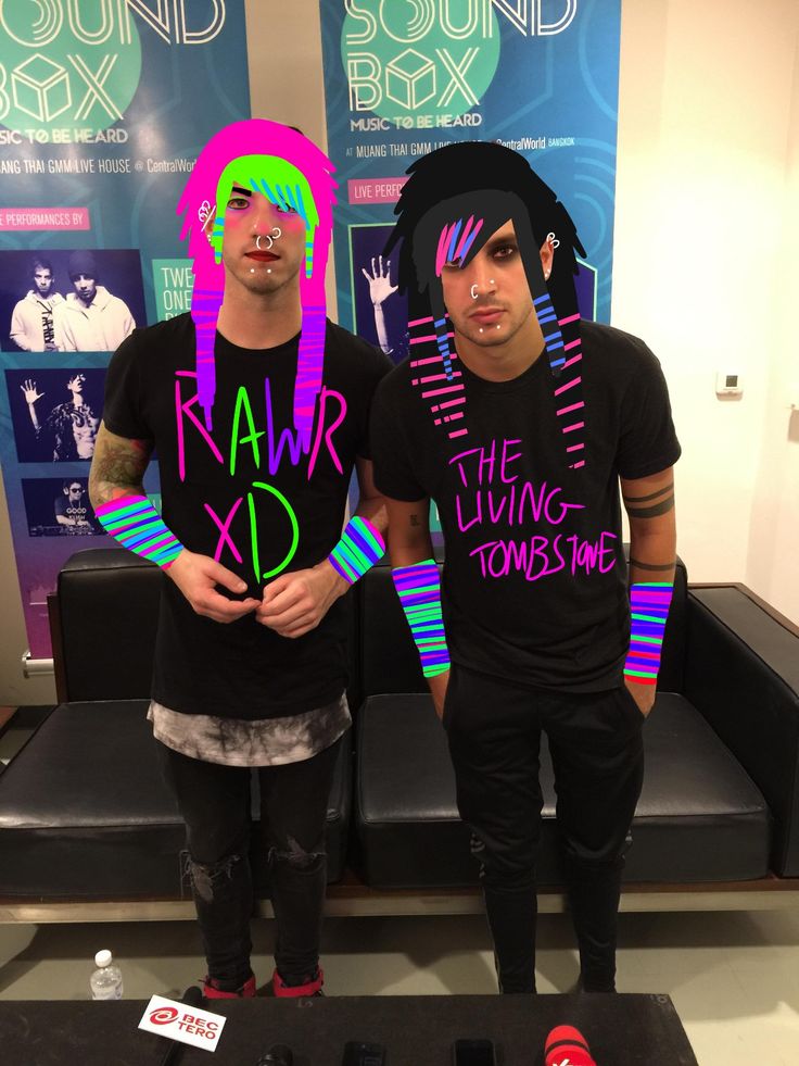 two young men standing next to each other in front of sound box signs and posters