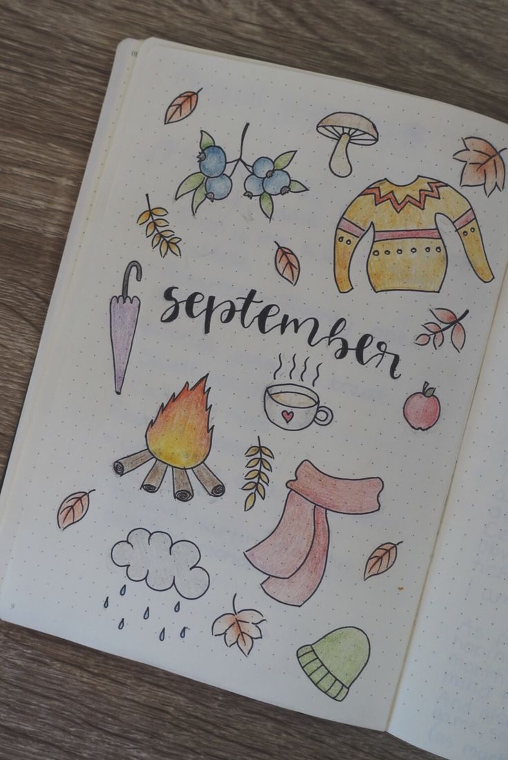 an open notebook with the words september written on it and various autumn related items around it