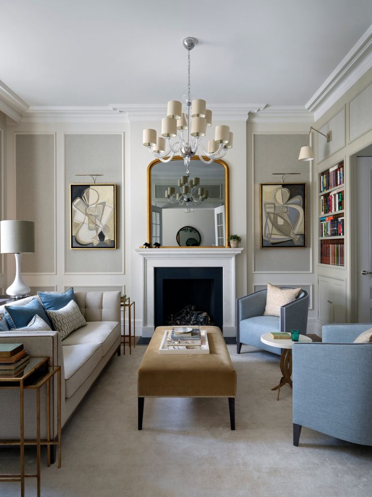 a living room filled with furniture and a fire place in front of a mirror on the wall