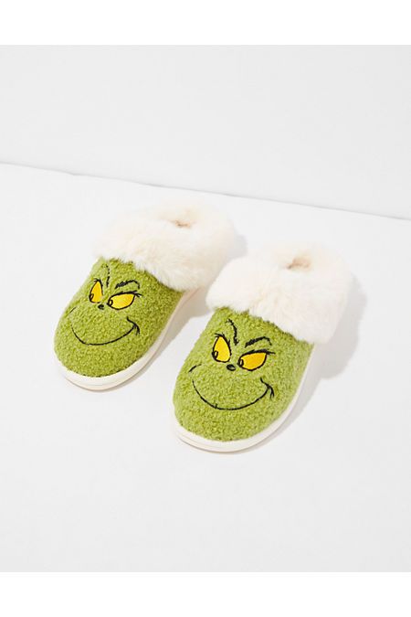 a pair of green slippers with yellow eyes and a grin face on the side