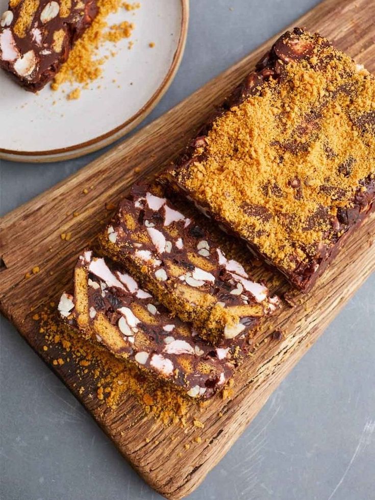 two slices of chocolate cake on a wooden cutting board next to a plate with another slice