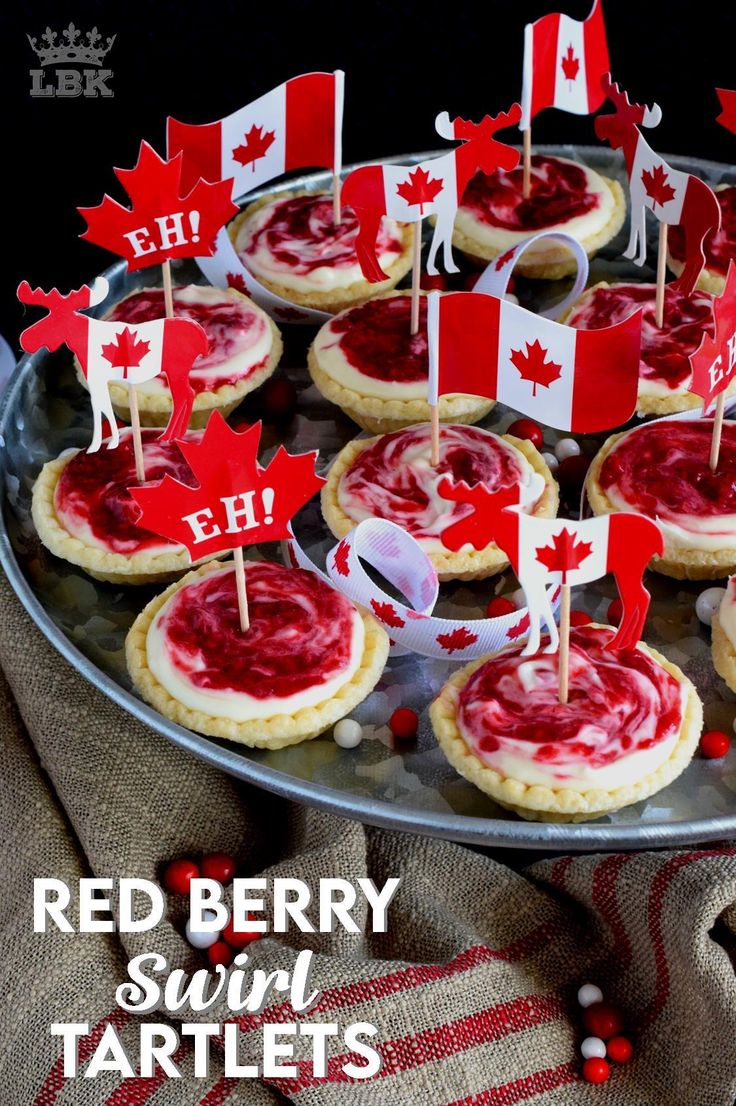 canadian flag desserts on a platter with red and white flags sticking out of them