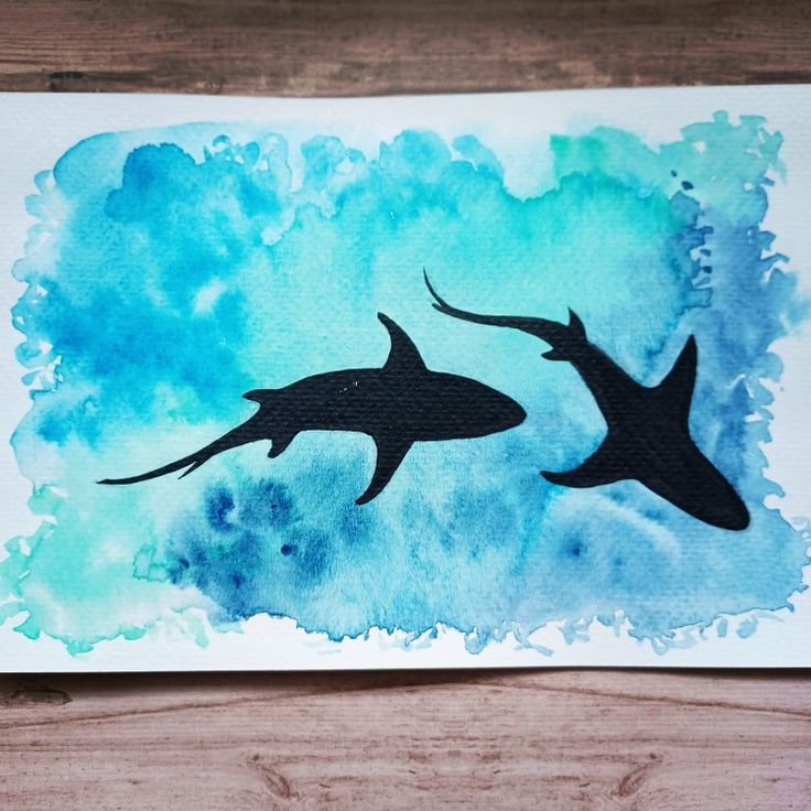 two black and white sharks on watercolor paper with blue sky in the back ground