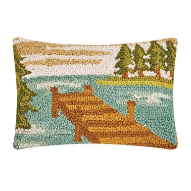 a decorative pillow with a boat on the water and trees in the background, it is made out of beads