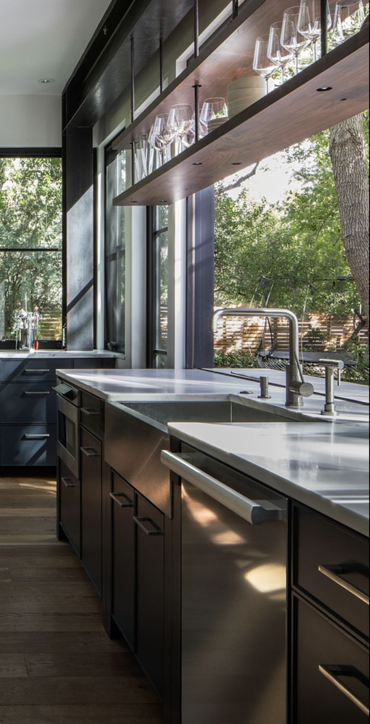 a modern kitchen with stainless steel appliances and wood flooring is pictured in this image