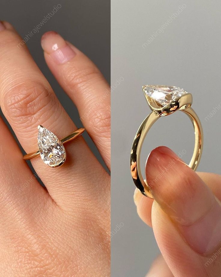 a woman's hand holding an engagement ring with a pear shaped diamond