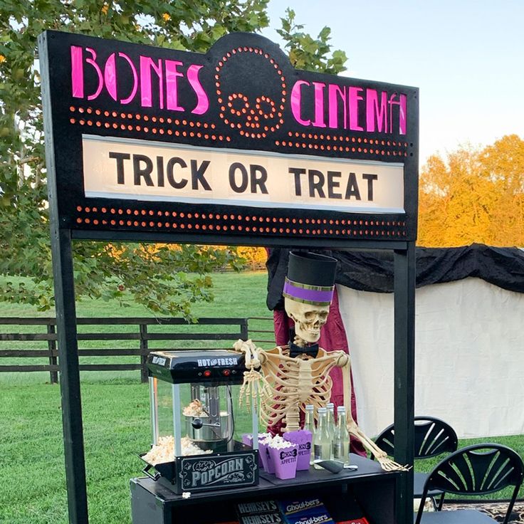 there is a sign that says bones and cinema trick or treat on the side of a table