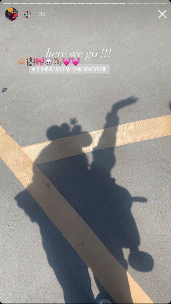 the shadow of a person riding a motorcycle down a street with a heart sticker on it's side