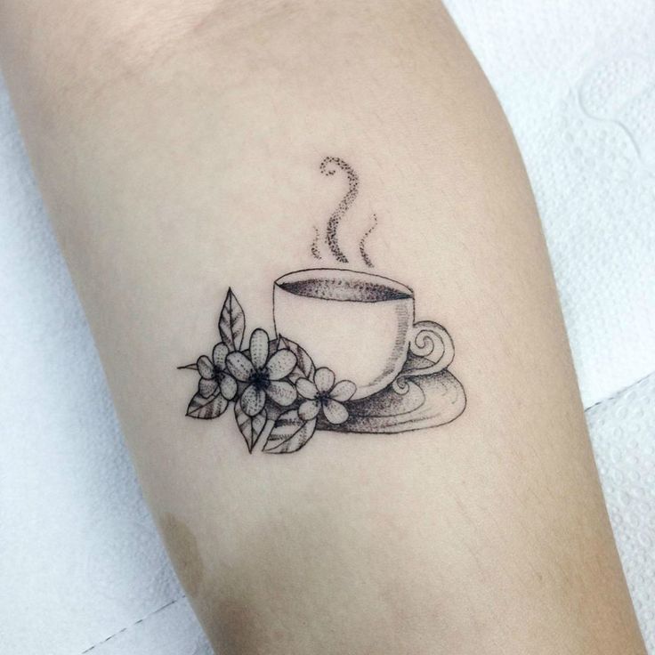 a cup of coffee and some flowers on the arm