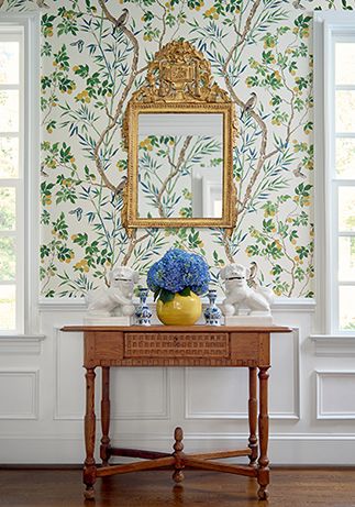 a table with a mirror and vase on it