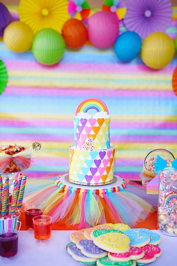 a table topped with lots of colorful cakes and desserts