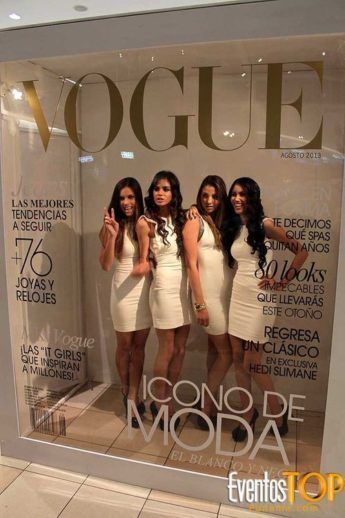 three beautiful young women standing in front of a magazine window