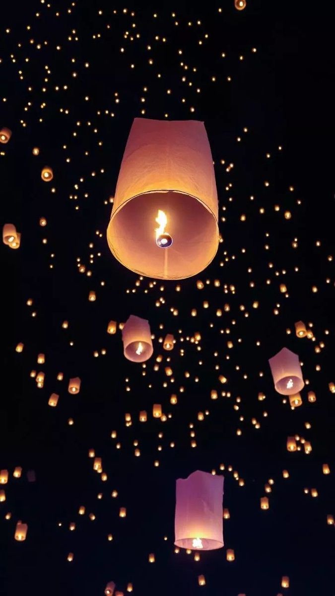 many lanterns floating in the air at night