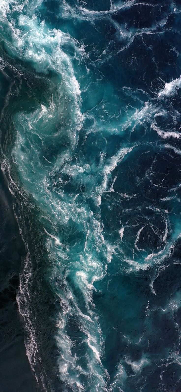 an aerial view of the ocean with waves and foamy blue water, from above