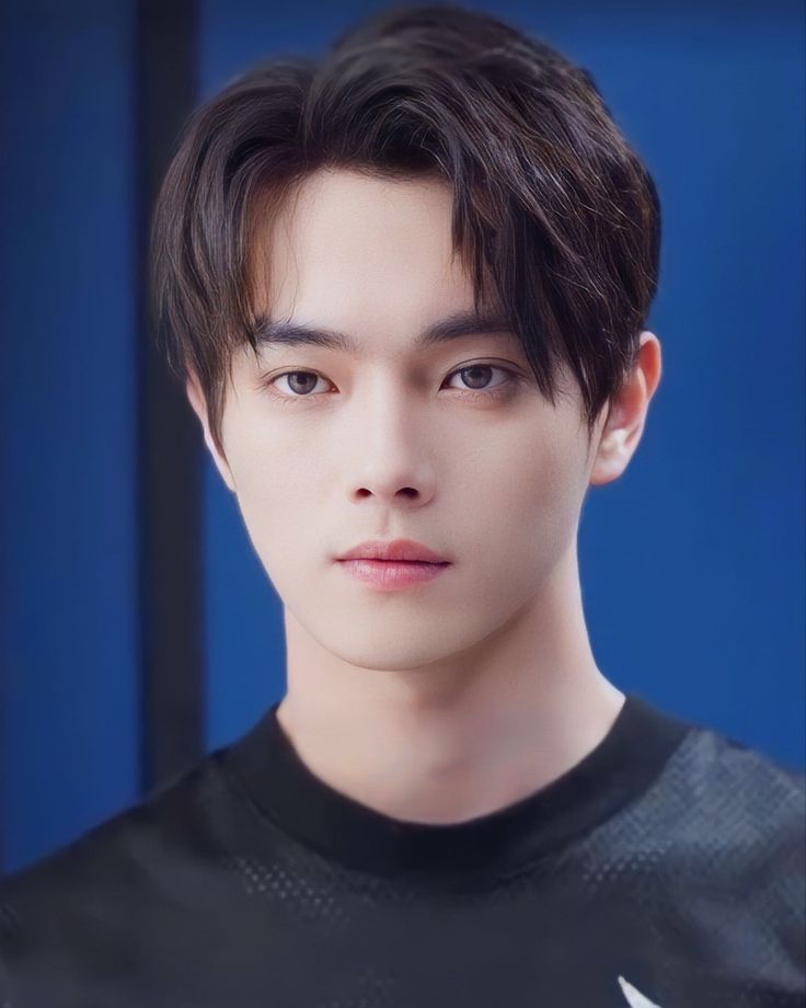 the young man is wearing a black t - shirt and looking at the camera with an intense look on his face