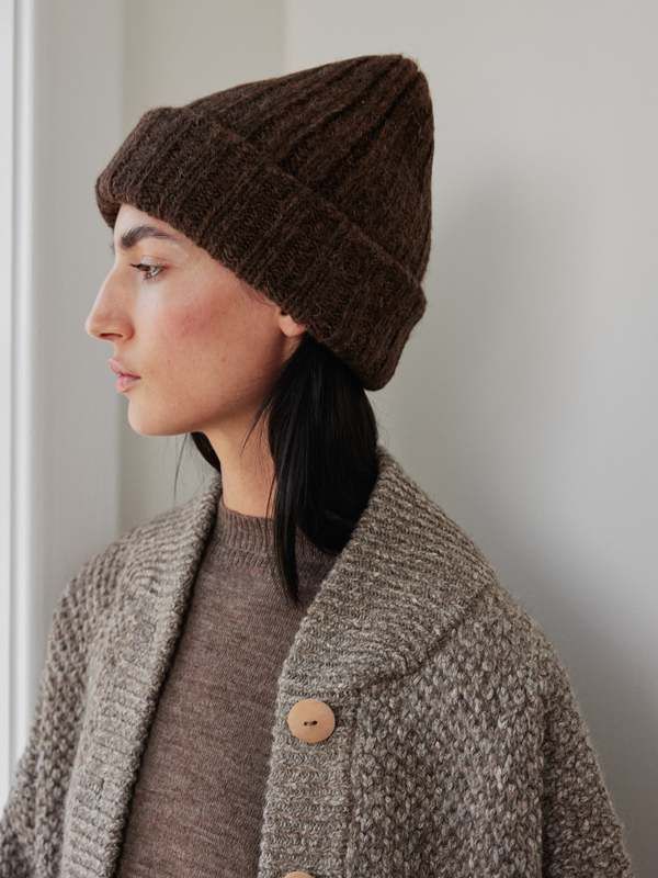 a woman wearing a brown knitted hat with buttons on the front and back of her head