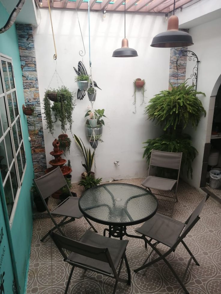 a patio with chairs, table and potted plants