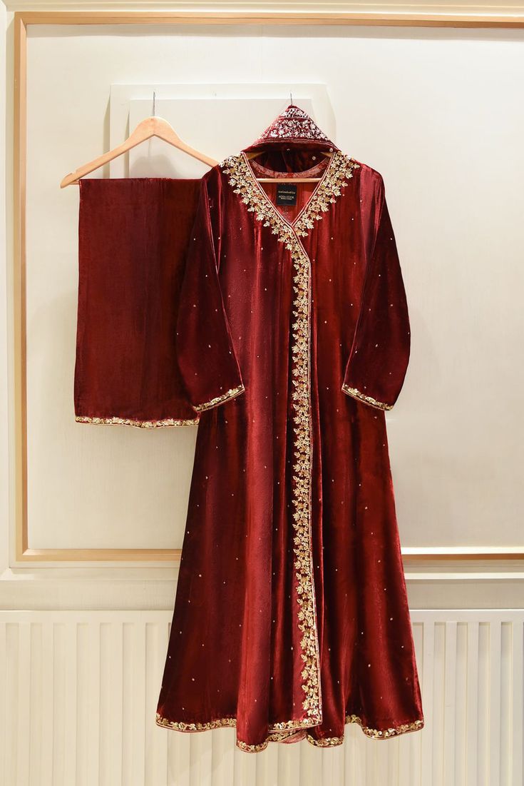 A heavily embellished beautiful three piece on pure dark maroon velvet, adorned with the most stunning hand/ada work of dabka, naqshi, sequins and crystals done by our skilled artisans. Paired with a heavily embellished pure velvet shawl and flappers featuring matching border. The length of the long angrakha is 48 inch Agha Noor, Bridal Shirts, Pakistani Party Wear, Velvet Dress Designs, Velvet Shawl, Dark Maroon, Pakistani Fancy Dresses, Pakistani Fashion Party Wear, Bridal Dress Fashion