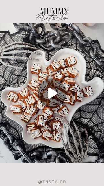 a white plate topped with lots of cookies on top of a lace covered table cloth