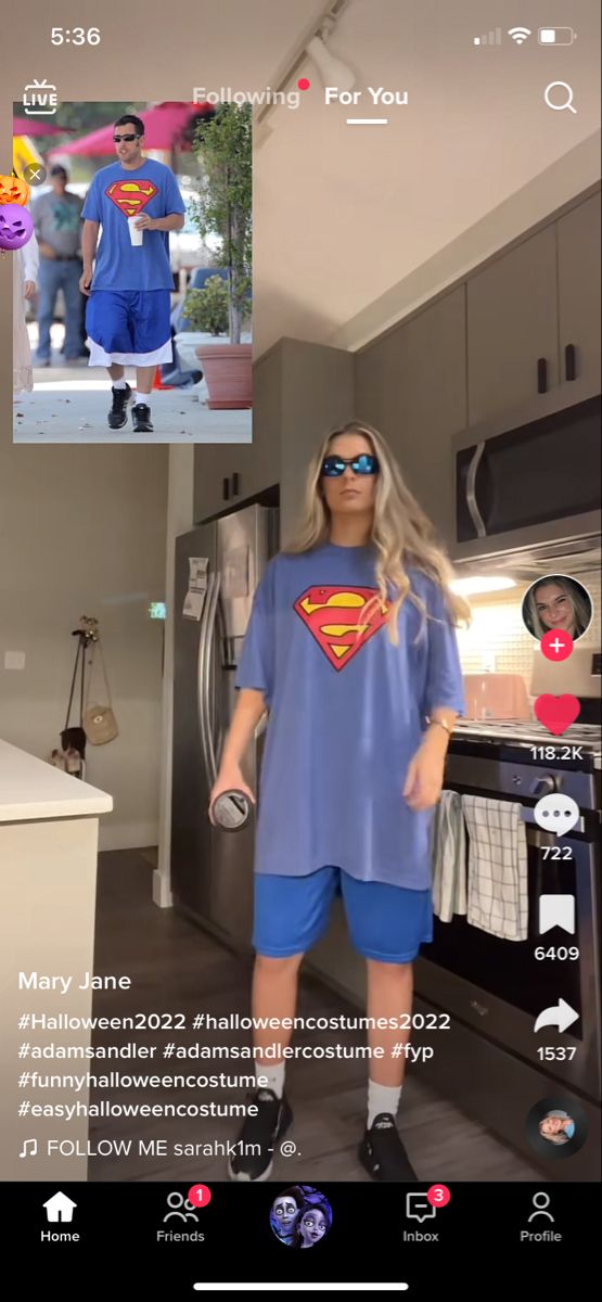 a woman in a superman t - shirt and blue shorts is taking a selfie