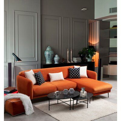 a living room with orange couches and white rugs on the floor in front of gray walls