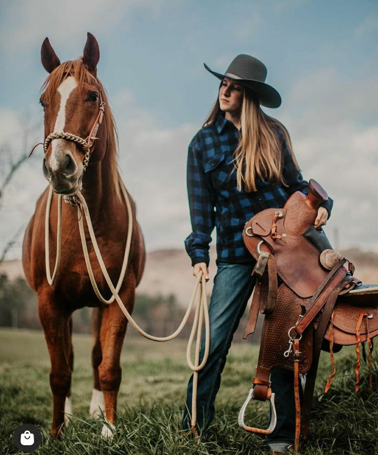 a woman is standing next to a horse wearing a cowboy hat and holding the reins