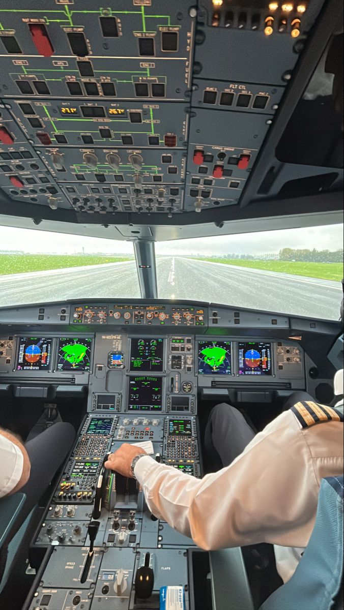 two pilots are sitting in the cockpit of an airplane looking at the flight path through the windows