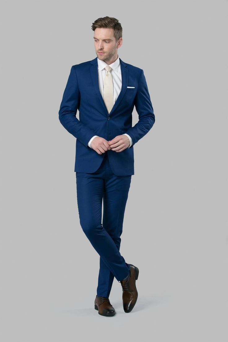 a man in a blue suit is posing for the camera with his hands on his hips