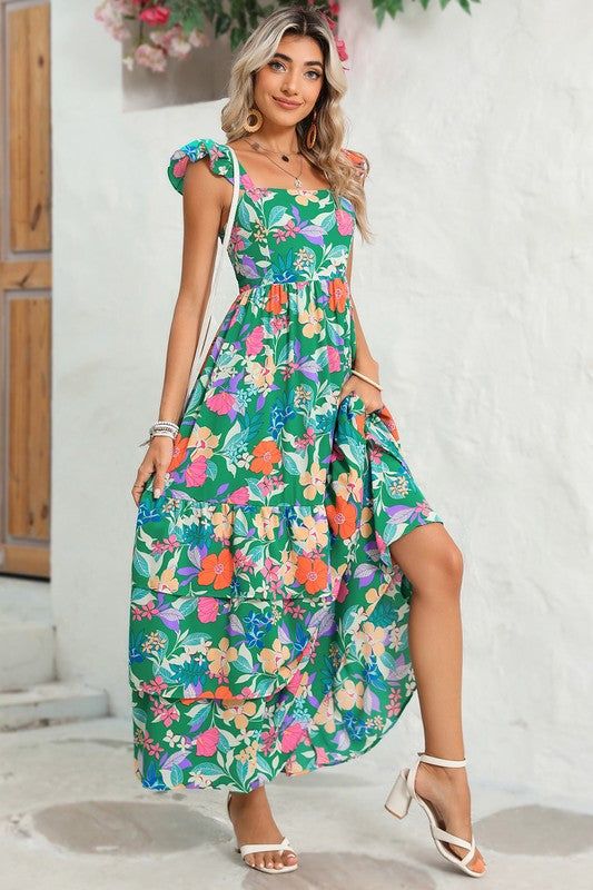 This flowy dress is perfect for warm weather or beach outings. The ruffled shoulder strap adds movement and an extra layer of visual interest. It showcases a vibrant and colorful floral pattern, creating a fresh and summery vibe The high waist design accentuates the curves and creates a feminine silhouette. Wholesale maxi dresses available for bulk orders, great for retailers Fabric Contents: Product Weight: 0.73 kgMaterial: 100%Polyester Shoulder Girdle, Boho Floral Maxi Dress, Maxi Dres, Casual Dress Pants, Timeless Dress, Boho Green, Feminine Silhouette, Maxi Dress Green, Tiered Maxi Dress