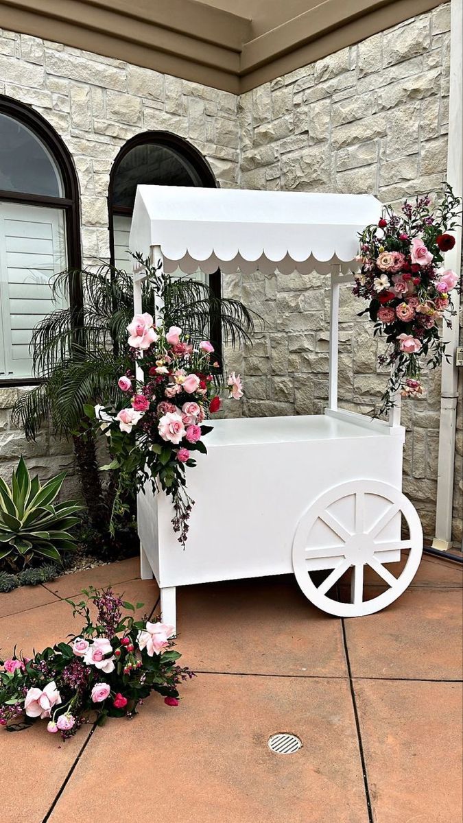 an ice cream cart decorated with flowers and greenery