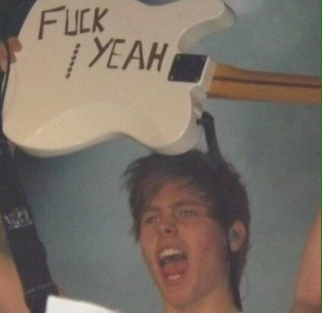 a young man holding up a guitar shaped like a rock and roll sign with the words flick yeah written on it