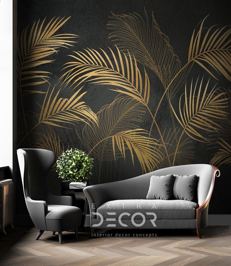 a couch and chair in front of a black wall with gold palm leaves on it