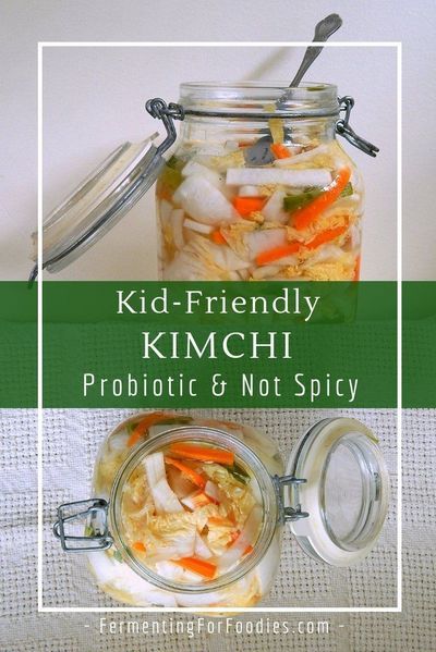 a jar filled with pickled vegetables sitting on top of a table next to a spoon